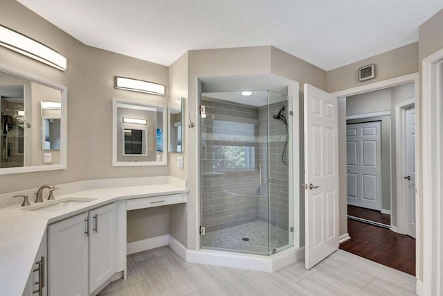 120 Jones Creek Dr, Jupiter, FL 33458 - bathroom featuring baseboards, a textured ceiling, a stall shower, and vanity
