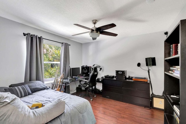 bedroom featuring dark hardwood / wood-style flooring, a textured ceiling, and ceiling fan