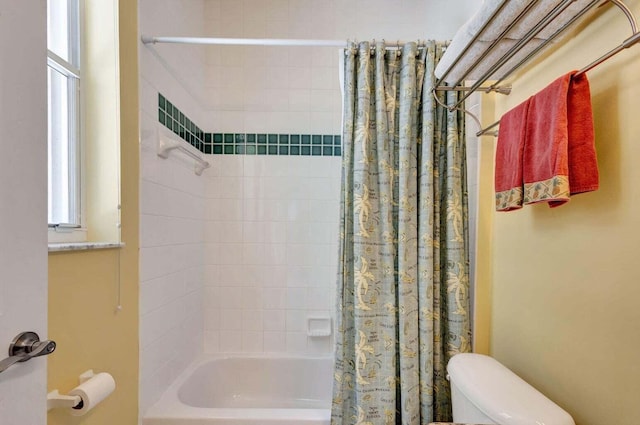 bathroom featuring shower / bath combination with curtain and toilet