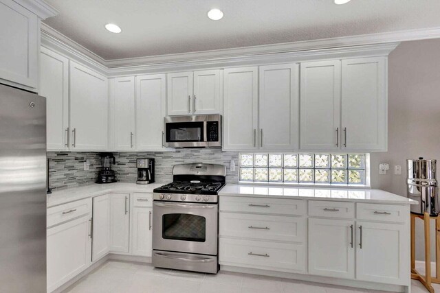 120 Jones Creek Dr, Jupiter, FL 33458 - kitchen with light countertops, stainless steel appliances, white cabinets, and tasteful backsplash
