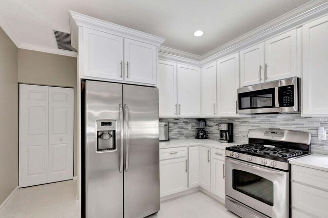 120 Jones Creek Dr, Jupiter, FL 33458 - kitchen featuring crown molding, visible vents, light countertops, white cabinetry, and stainless steel appliances