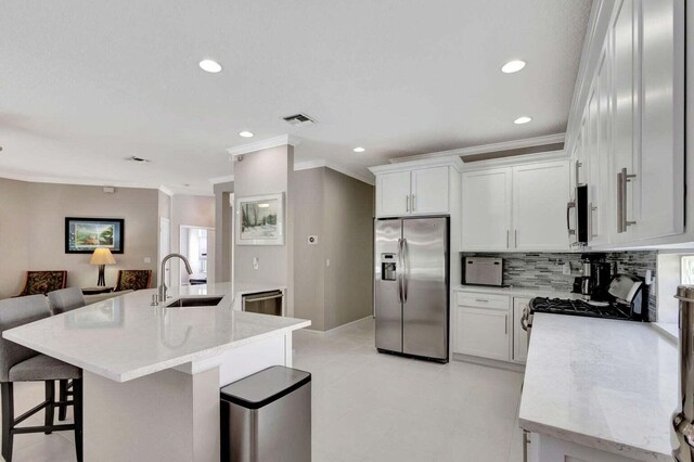 120 Jones Creek Dr, Jupiter, FL 33458 - kitchen with appliances with stainless steel finishes, a sink, a kitchen breakfast bar, visible vents, and ornamental molding