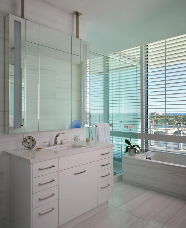 bathroom featuring vanity and tiled tub