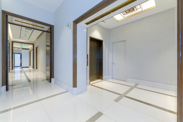 corridor featuring light tile patterned floors and elevator