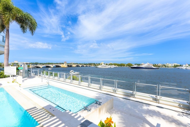 view of pool featuring a patio area and a water view