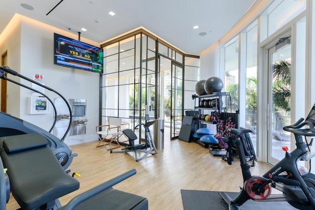 gym featuring wood-type flooring and french doors