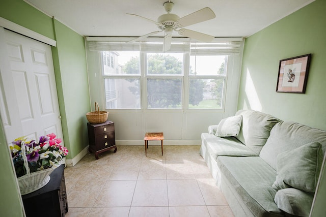 living area featuring ceiling fan, light tile patterned floors, and a wealth of natural light