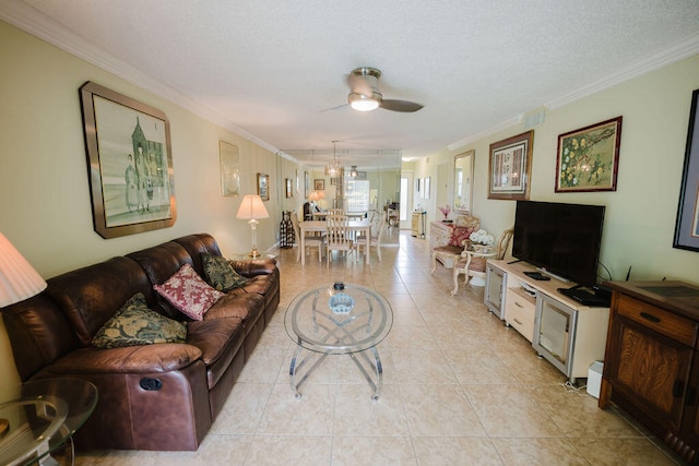 tiled living room with ceiling fan, a textured ceiling, and ornamental molding