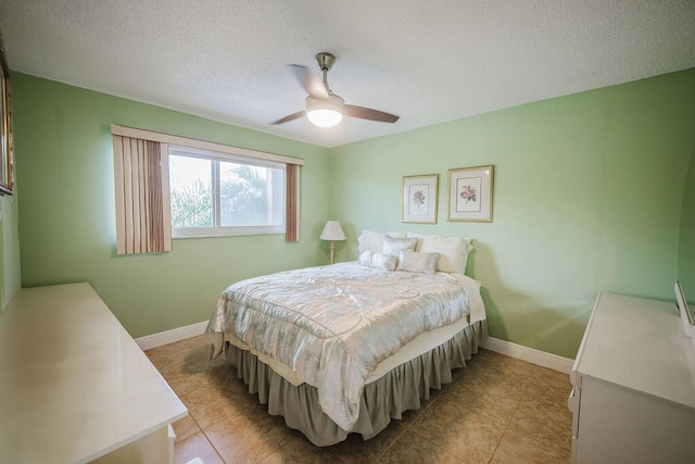 bedroom featuring light tile patterned flooring, a textured ceiling, and ceiling fan