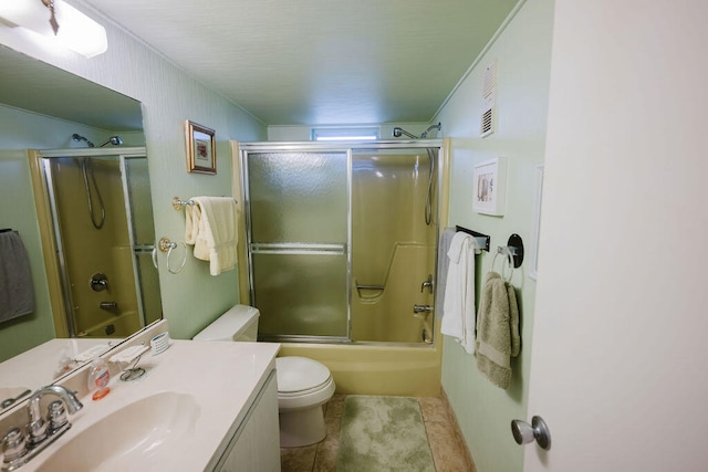 full bathroom featuring tile patterned floors, vanity, enclosed tub / shower combo, and toilet