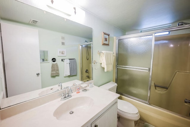 full bathroom featuring tile patterned floors, bath / shower combo with glass door, toilet, and vanity