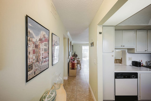 hallway featuring a textured ceiling and light tile patterned floors