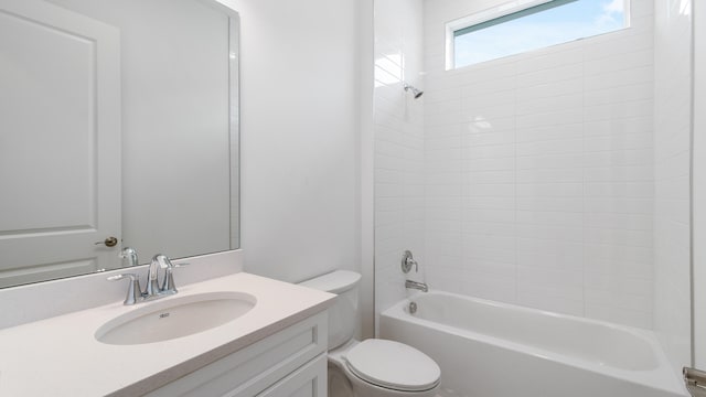 full bathroom with tiled shower / bath, vanity, and toilet