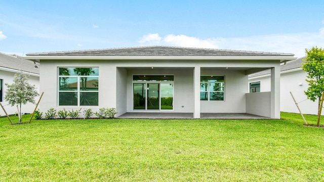 back of house featuring a lawn and a patio area