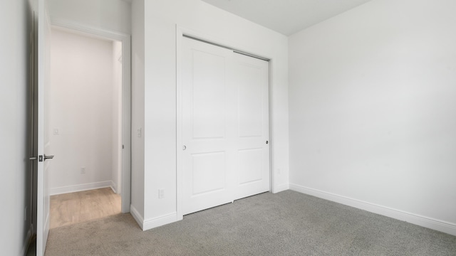 unfurnished bedroom featuring carpet floors and a closet