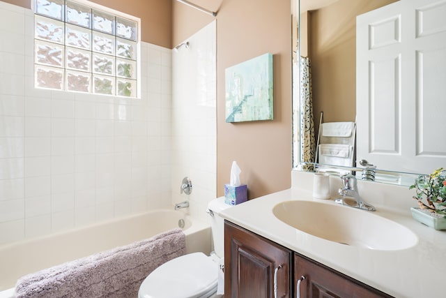 full bathroom featuring tiled shower / bath combo, vanity, and toilet