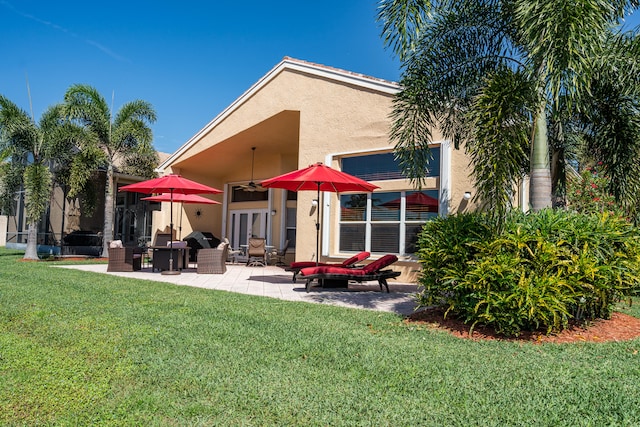 rear view of property with a patio and a lawn