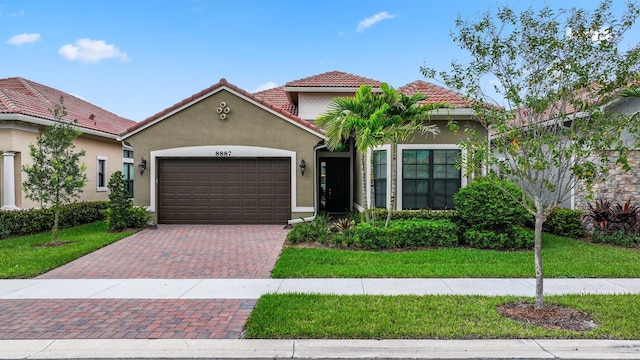 mediterranean / spanish house with a garage and a front lawn