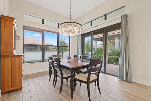 dining area with an inviting chandelier, decorative columns, and light hardwood / wood-style floors