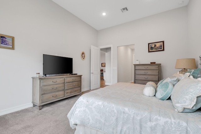 bedroom featuring light colored carpet and high vaulted ceiling