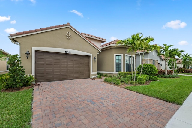 mediterranean / spanish-style home featuring a garage and a front lawn