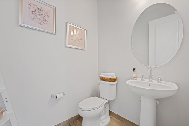 bathroom featuring hardwood / wood-style flooring and toilet