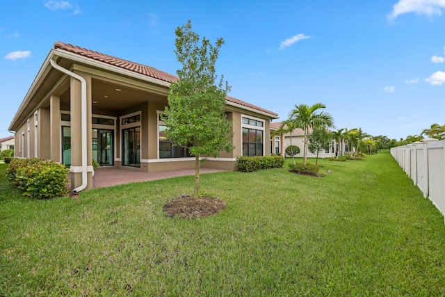 rear view of house with a lawn and a patio