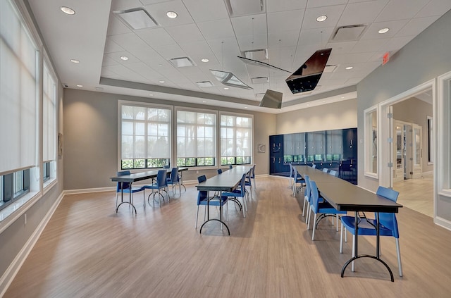 rec room with light wood-type flooring and a tray ceiling