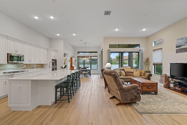 living room featuring light wood-type flooring and an inviting chandelier