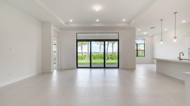 empty room with a raised ceiling and sink