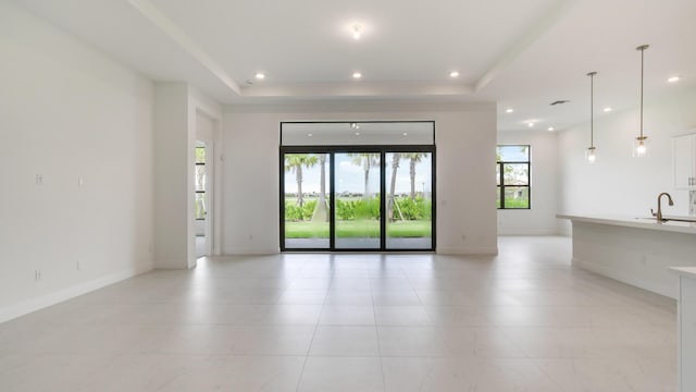 5237 Saint Vincent Ln, Westlake, FL 33470 - unfurnished living room featuring a tray ceiling, recessed lighting, light tile patterned flooring, a sink, and baseboards