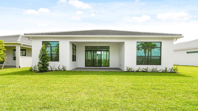 back of house with a lawn and a patio area