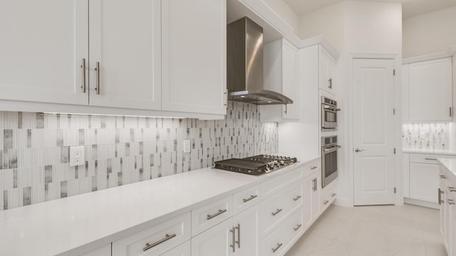 5237 Saint Vincent Ln, Westlake, FL 33470 - kitchen with wall chimney range hood, stainless steel appliances, white cabinetry, and backsplash