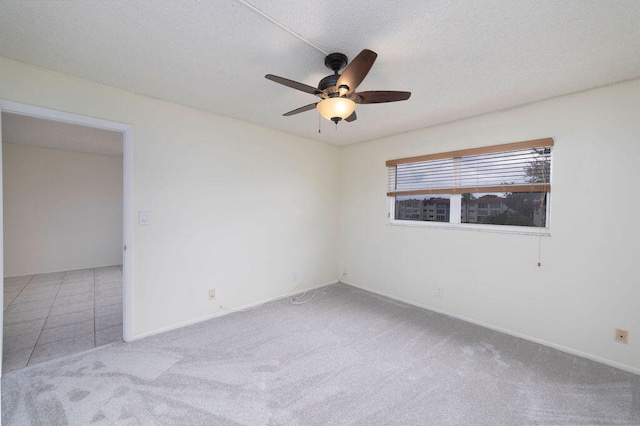 unfurnished room featuring light colored carpet, a textured ceiling, and ceiling fan