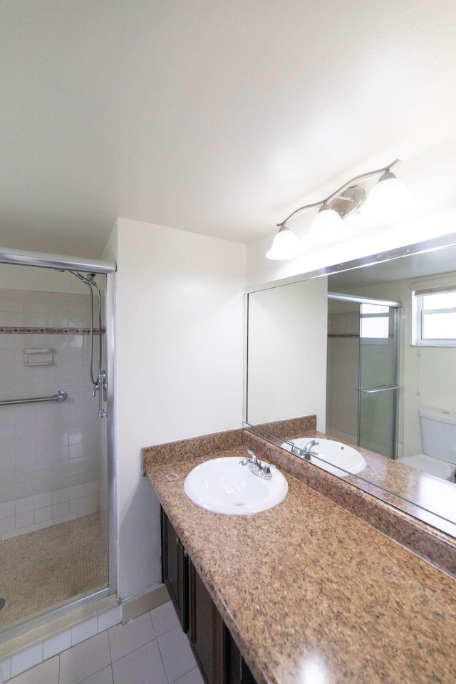 bathroom with tile patterned floors, an enclosed shower, vanity, and toilet