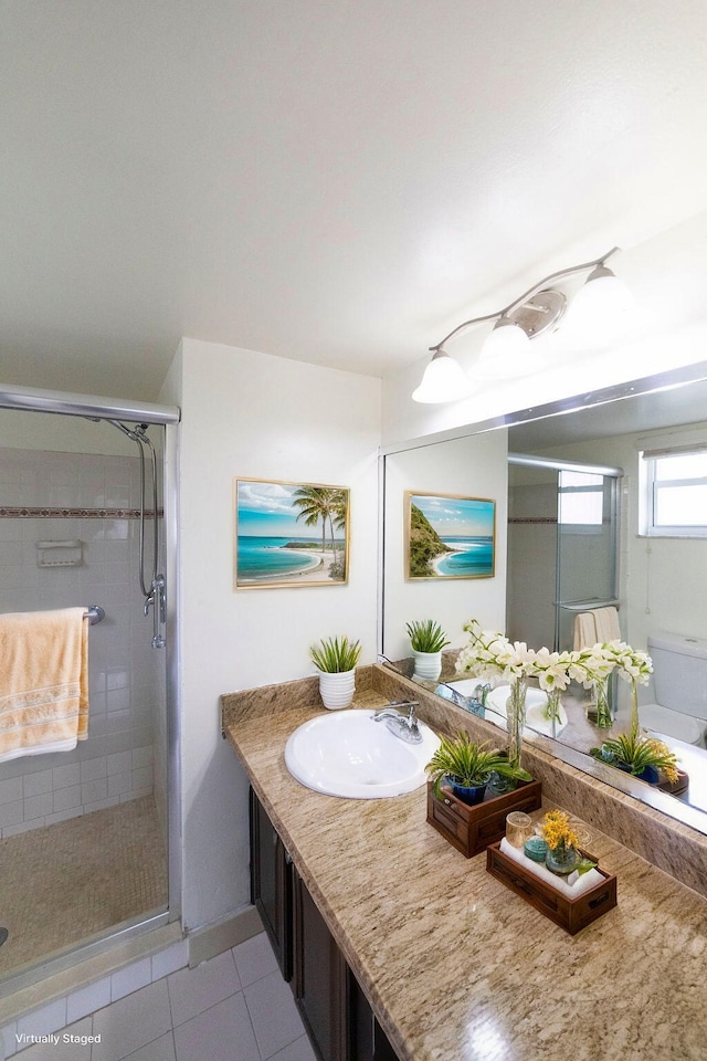 bathroom featuring tile patterned floors, toilet, vanity, and a shower with shower door