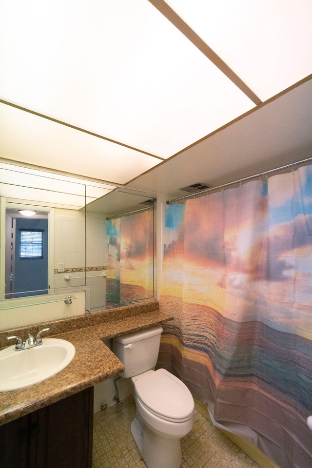 bathroom featuring curtained shower, vanity, and toilet