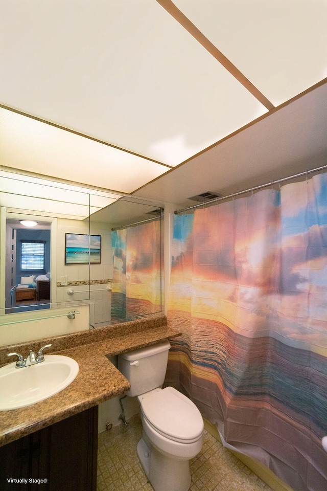 bathroom featuring vanity, toilet, and a shower with shower curtain