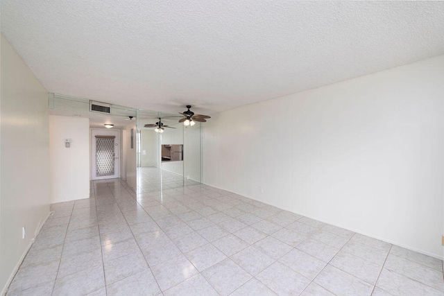 empty room featuring ceiling fan and a textured ceiling