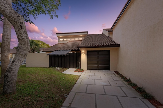 view of front of house with a garage and a lawn