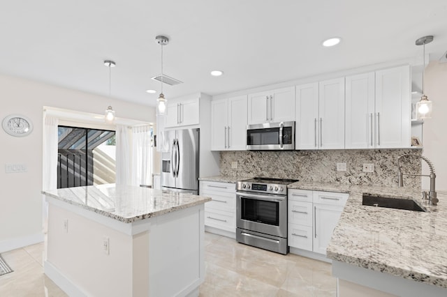 kitchen featuring white cabinetry, stainless steel appliances, sink, and hanging light fixtures