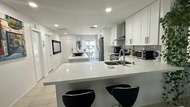 kitchen with white cabinetry, sink, kitchen peninsula, a breakfast bar, and appliances with stainless steel finishes