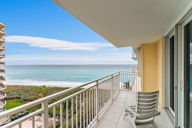 balcony with a water view and a view of the beach