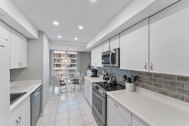 kitchen featuring sink, white cabinets, light tile patterned floors, and appliances with stainless steel finishes