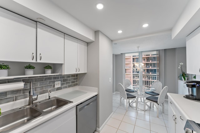 kitchen with sink, white cabinetry, dishwasher, light tile patterned floors, and backsplash