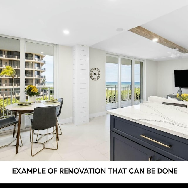 kitchen with floor to ceiling windows, light stone counters, and beamed ceiling