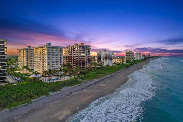 outdoor building at dusk with a water view and a view of the beach