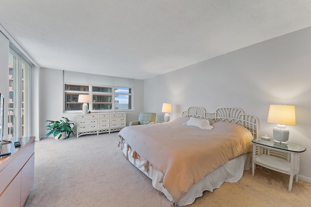 bedroom featuring a textured ceiling, light carpet, and multiple windows