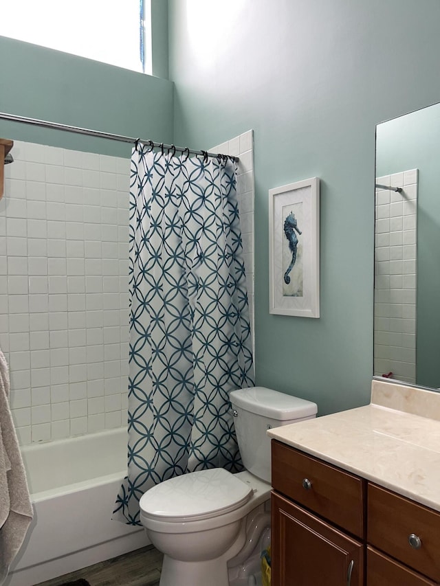 full bath featuring wood finished floors, shower / bath combo with shower curtain, toilet, and vanity