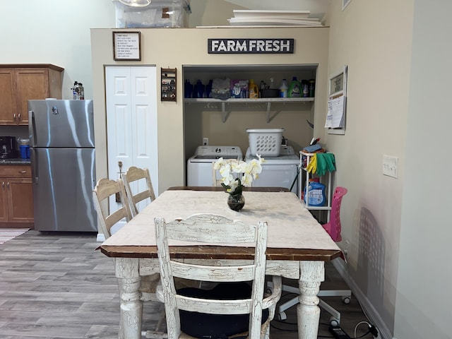 dining space with washing machine and clothes dryer and light wood-type flooring